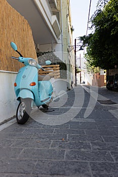 Walk around the old town. narrow street on which stands a blue scooter