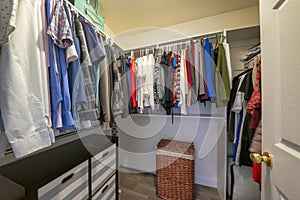 Walk in closet with an open wardrobe with metal rods