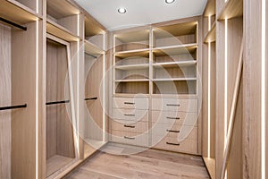 a walk in closet with wooden shelves and drawers and open shelvings