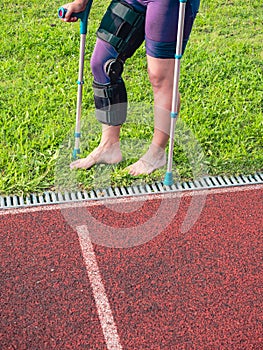 Walk by crutches. Woman runner got sports injury