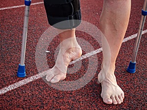 Walk by crutches. Woman runner got sports injury