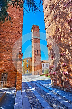 Walk between medieval towers on Piazza Leonardo da Vinci in old Pavia, Italy