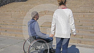 Walk in park invalid on wheel chair and girlfriend, Couple lovers