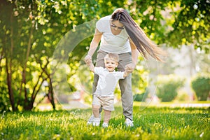 Walk in park mom and son, first step, learn to go child. Concept family