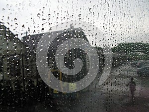 Walk in the rain of person near roadside cafe. Blurred