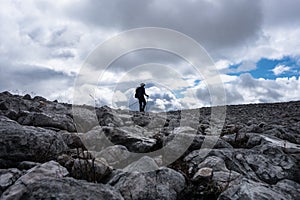Walker silhouette on rock field on Scottish Highland Munro