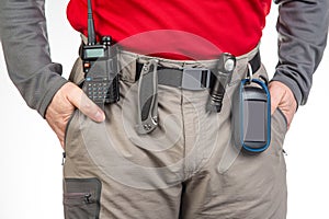 walkie-talkie, flashlight, knife, GPS navigator on the belt of the tourist trekking pants. equipment for tourism and travel. EDC