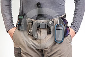 walkie-talkie, flashlight, knife, GPS navigator on the belt of the tourist trekking pants. equipment for tourism and travel. EDC