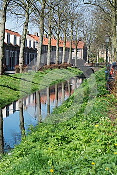 Walking along the small canal in old Dutch village, sunny Sunday