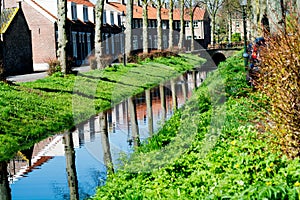 Walking along the small canal in old Dutch village, sunny Sunday