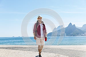 Walking american hipster tourist at Ipanema beach at Rio de Janeiro