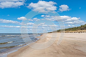 Walking on the Baltic Sea in Palanga, Klaipeda, Lithuania, with waves, cloudy sky, white sandy beach and dunes