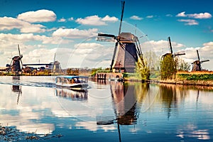 Walking boat on the famoust Kinderdijk canal with windmills. Old Dutch village Kinderdijk, UNESCO world heritage site. Netherlands
