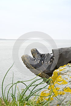 Walking boots with sea in background