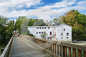 Walking bridge on Du Chene river with The Legare mill in the background photo