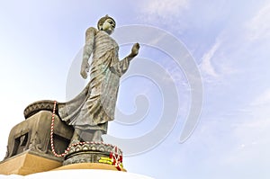 Walking Buddha against blue sky