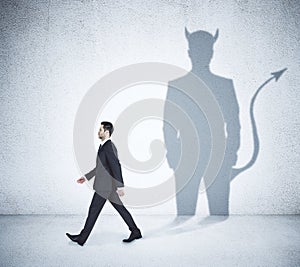Walking businessman with devil shadow
