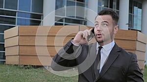 Walking Businessman Talking on Phone