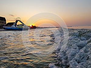 Walking catamaran against the backdrop of sunrise on the sea.