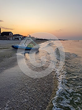 Walking catamaran against the backdrop of sunrise on the sea.