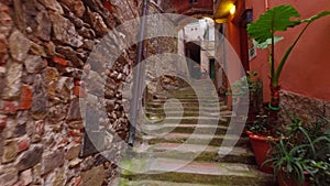 Walking through characteristic street with stone stairs in the hinterland in Cinque Terre. Ancient houses made with