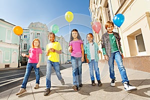 Walking children diversity with colorful balloons