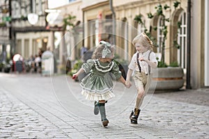 Walking children on the street.The boy and the girl in motion , to run together . Photos in retro style . Pavers in the city