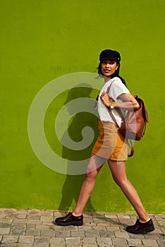 Walking with confidence in my step. Full length shot of an attractive young woman walking against a green background