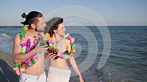 Walking couple in love, guy holding girl by hand, an exotic vacation, on background beach panorama, summer, slow motion,