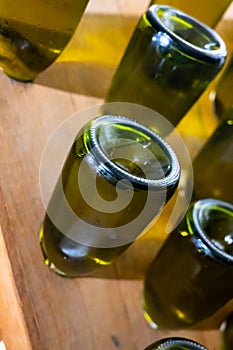 Walking in deep and long undergrounds caves with dusty bottles on racks, making champagne sparkling wine from chardonnay and pinor