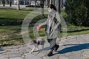 walking dog in the park with face mask