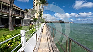 Walking famous Waikiki beach. Warm waves of the Pacific Ocean wash over a tropical Waikiki beach. Turquoise water