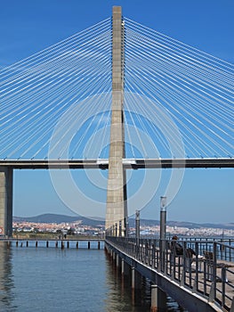 Walking the footpath Passeio do Tejo along Tagus river in Lisbon at the Expo park - Vasco da Gama bridge