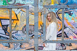 Walking girl wearing blank white t-shirt, posing against rough street wall, minimalist urban clothing style, mock up for