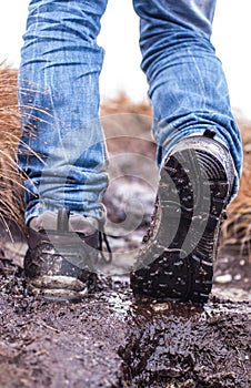 Walking hiking shoes on a muddy terrain photo