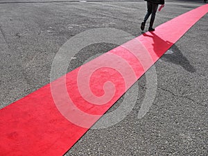 Walking lonely man on red carpet close view on legs