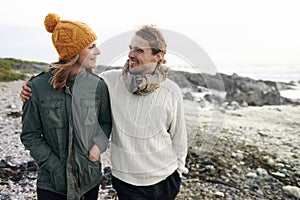 Walking, love and couple by ocean in winter for bonding, romantic relationship and relax outdoors. Marriage, travel and