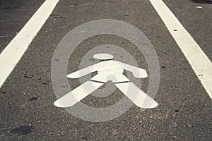 Walking man pavement sign painted white on concrete way