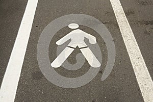 Walking man pavement sign painted white on concrete way