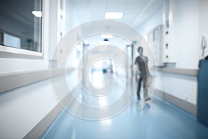 Walking medical person in hospital hall, unfocused background