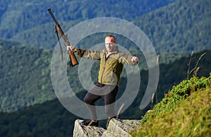 Walking in mountains. Man brutal gamekeeper nature landscape background. Hunting masculine hobby concept. Regulation of photo