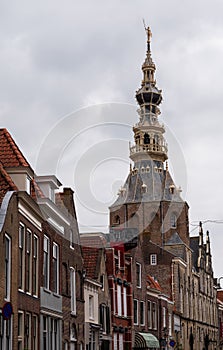 Walking in old Dutch town Zierikzee with old church tower, small houses and streets