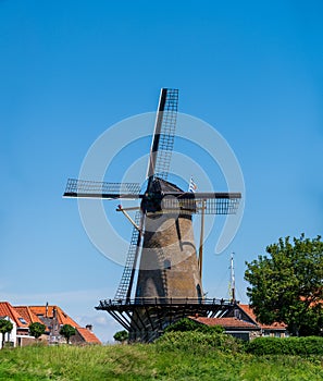 Walking in old Dutch town Zierikzee with old windmill, small houses and streets