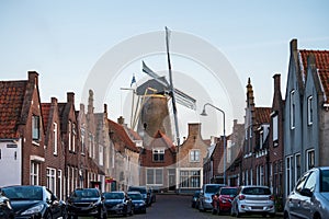 Walking in old Dutch town Zierikzee with old windmill, small houses and streets