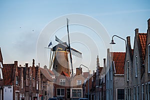 Walking in old Dutch town Zierikzee with old windmill, small houses and streets