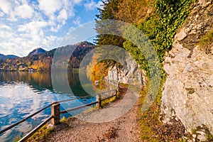 Walking path with a fence along alpine lake Wolfgangsee in austrian Alps