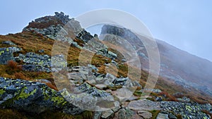 Walking path on a rocky mountain ridge during foggy weather, Low Tatras, Slovakia