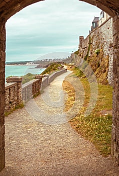 Walking path, trail through arched stone door on a beach