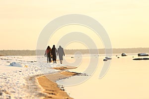 Walking people on the coast of sea at winter time