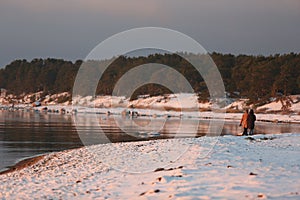 Walking people on the coast of sea at winter time